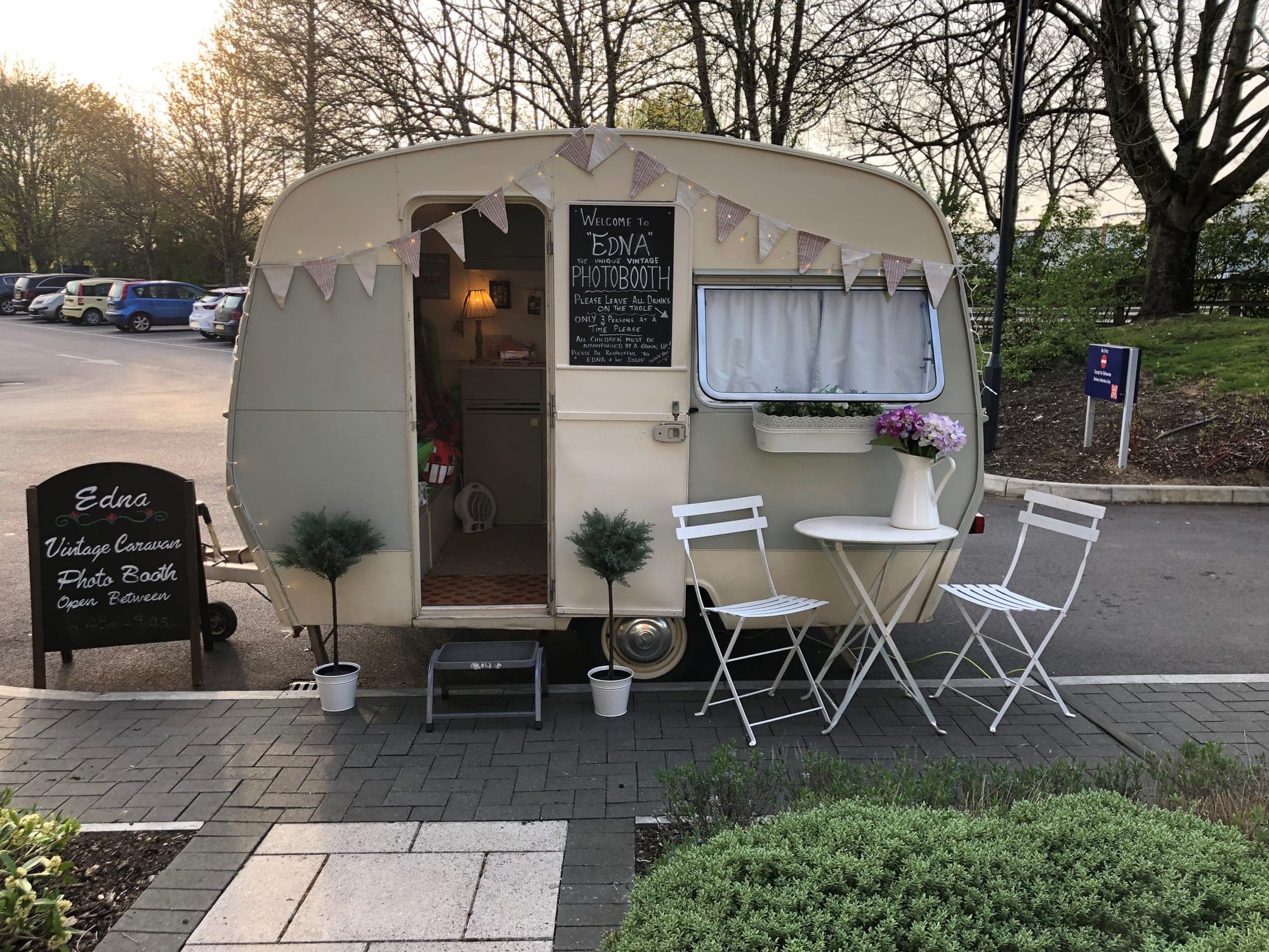Edna set up at golden hour, bunting up, welcome board out and the bistro table beside her